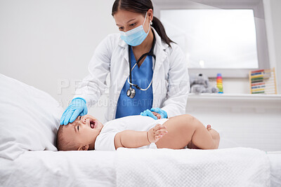 Buy stock photo Shot of a doctor feeling a baby's temperature in a hospital