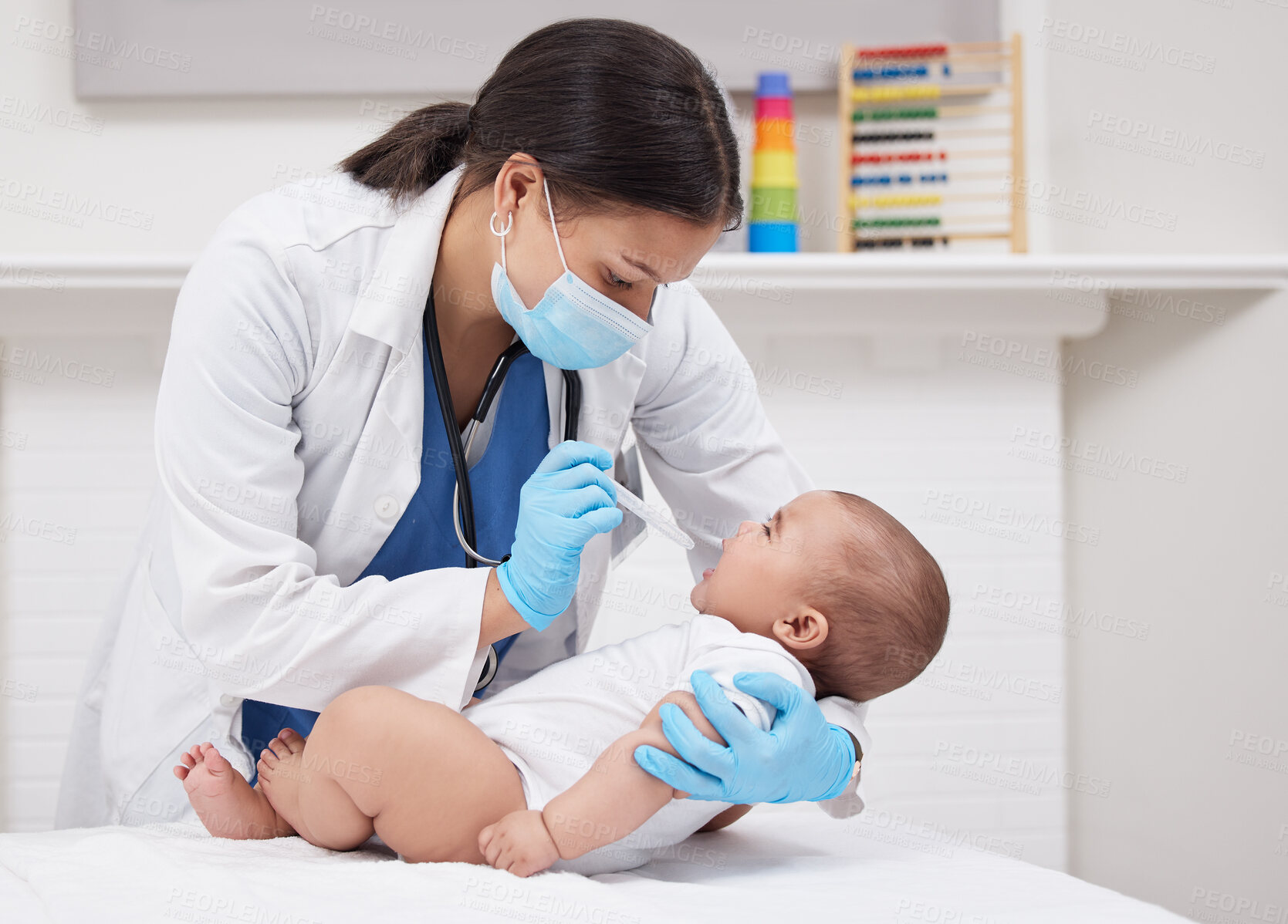 Buy stock photo Shot of a doctor giving medicine to a baby in a hospital
