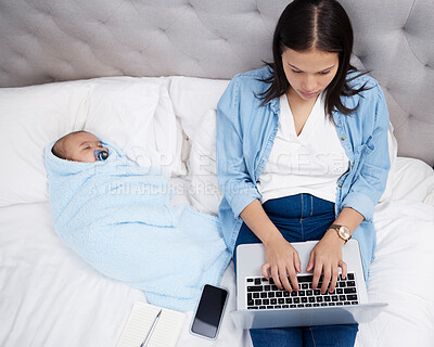 Buy stock photo Shot of a mother using her laptop while her baby sleeps on the bed