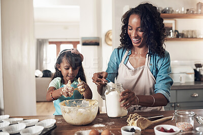 Buy stock photo Shot of a woman baking at home with her young daughter