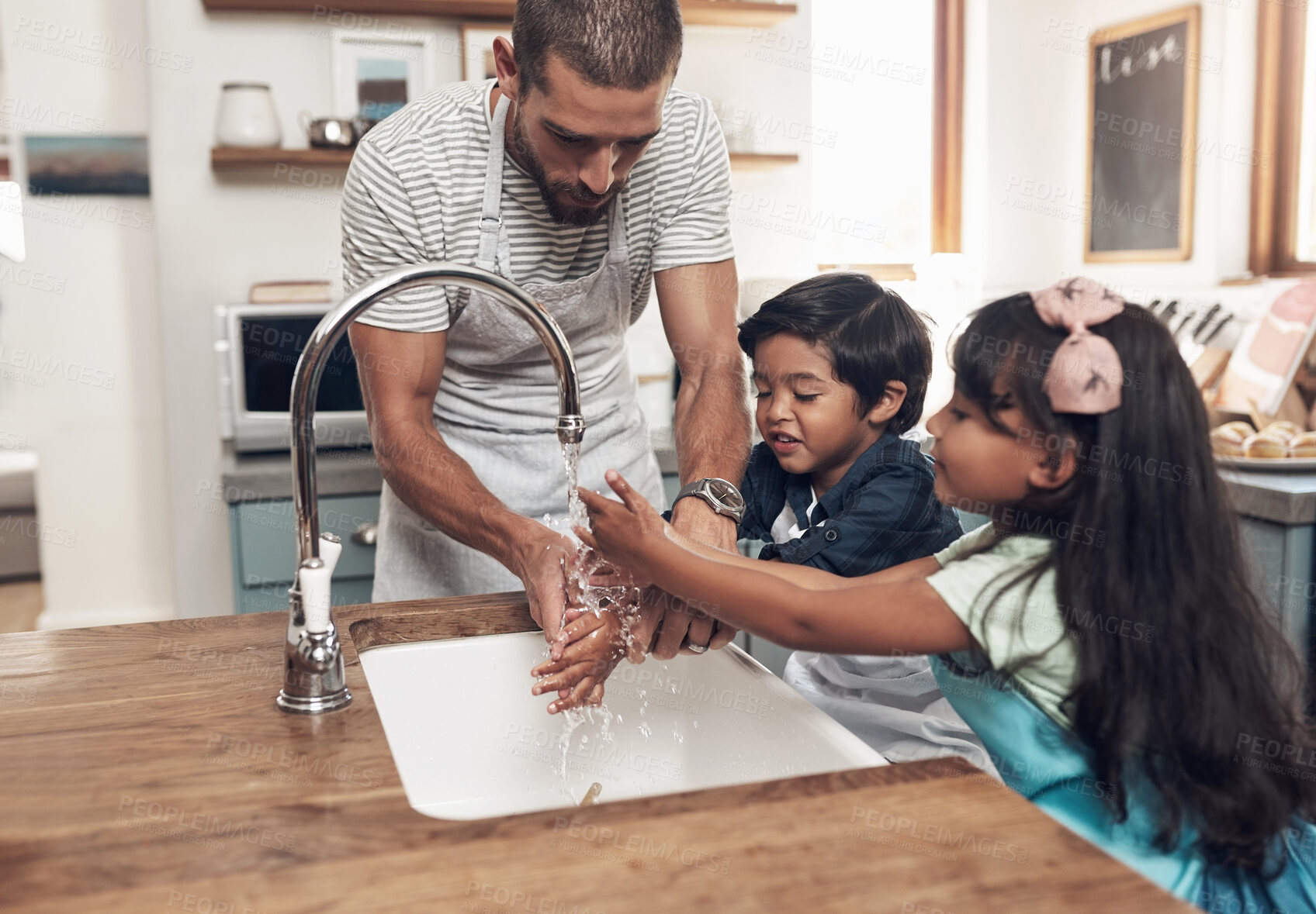 Buy stock photo Shot of a man and his two children washing their hands in the kitchen basin