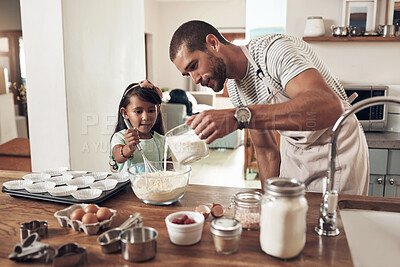 Buy stock photo Shot of a father teaching his daughter how to bake in the kitchen at home
