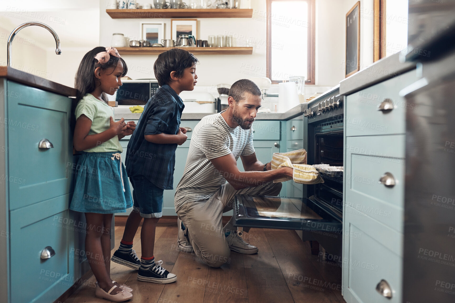 Buy stock photo Shot of a young man baking at home with his two young kids