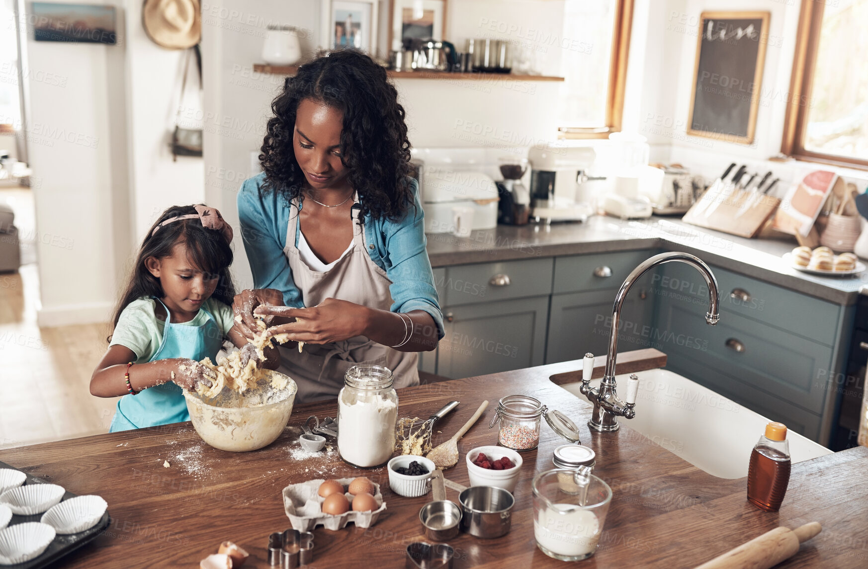 Buy stock photo Baking, learning and mother with daughter in kitchen for bonding, food and help. Cooking, love and cupcake with people and ingredients in family home for breakfast, teaching and happiness together