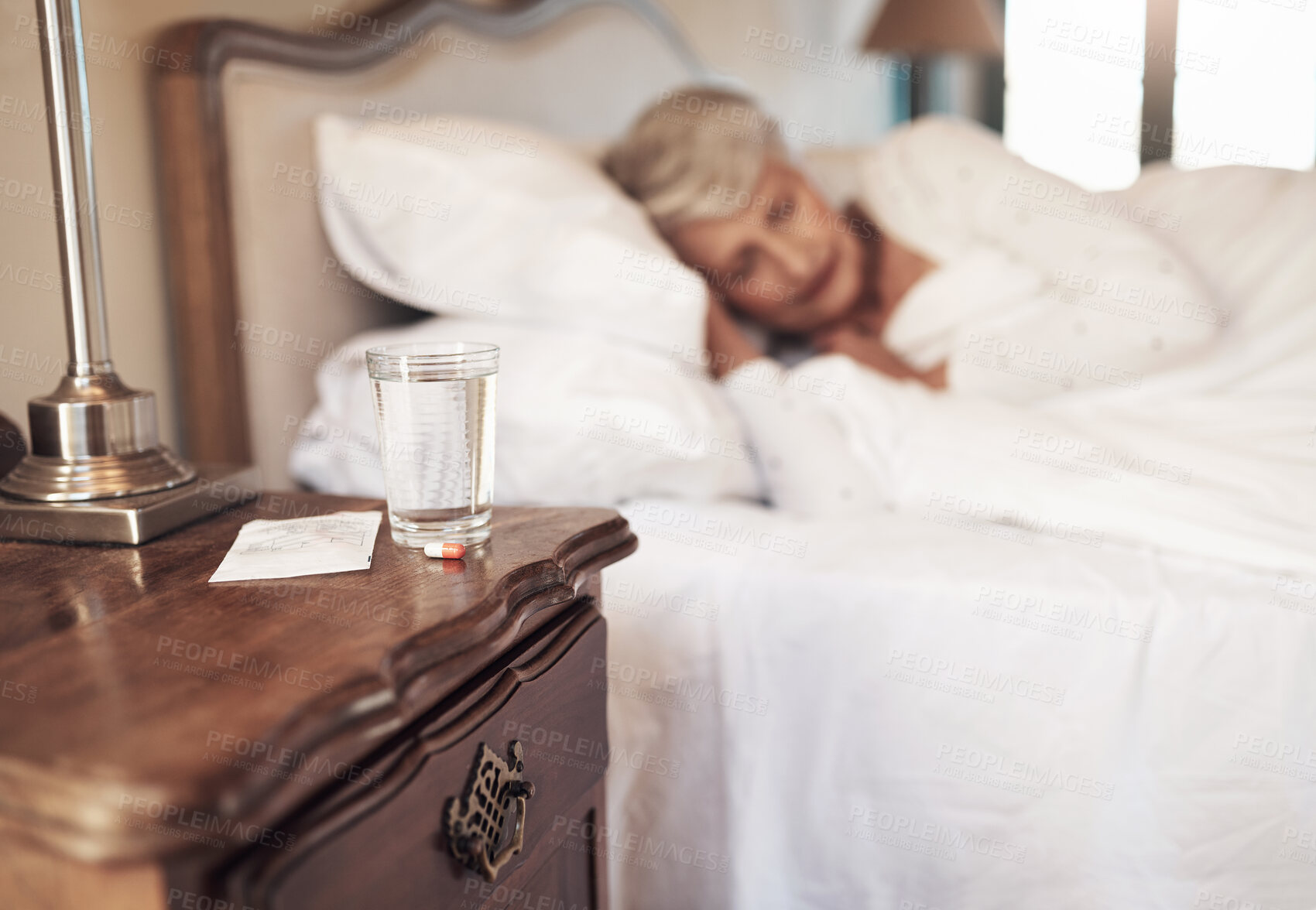 Buy stock photo Water, home and sleeping pills for senior woman, insomnia treatment and drugs for pain in retirement. Female person, nap and table for medication in bedroom, liquid and ketamine tablets to dream