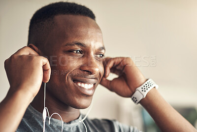 Buy stock photo Shot of a sporty young man listening to music while exercising at home
