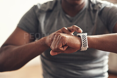Buy stock photo Closeup shot of an unrecognisable man checking his wristwatch while exercising at home