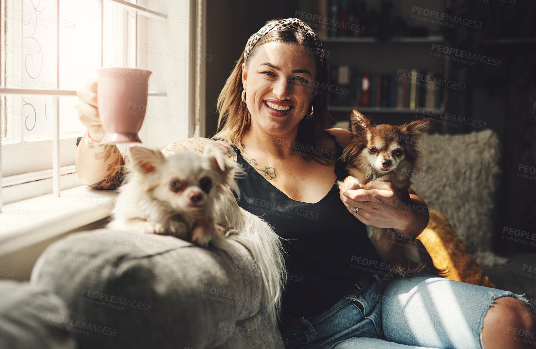 Buy stock photo Shot of a young woman having coffee and relaxing with her dogs on the sofa at home