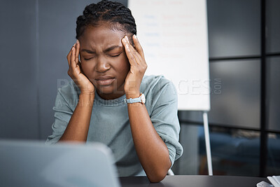 Buy stock photo Shot of a young businesswoman looking stressed out while working on a laptop in an office