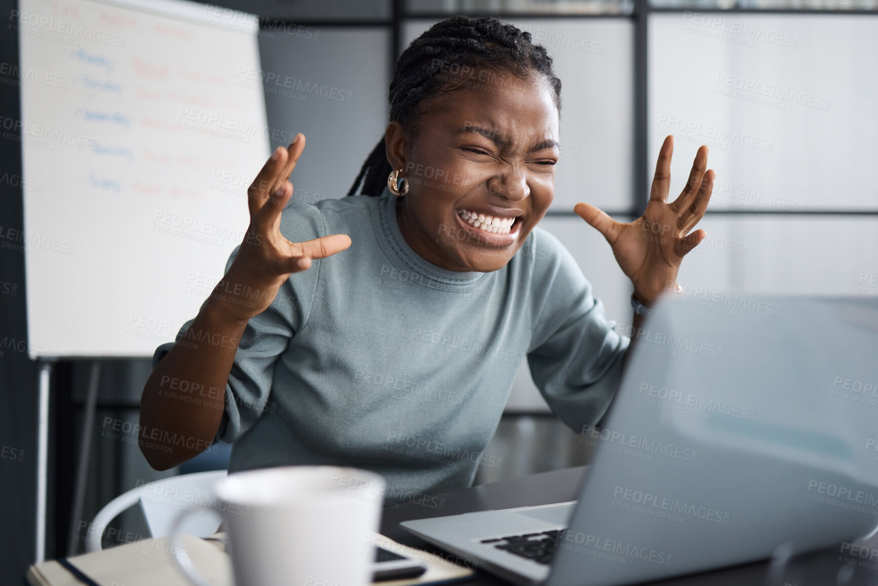 Buy stock photo Shot of a young businesswoman looking angry while using a laptop in an office