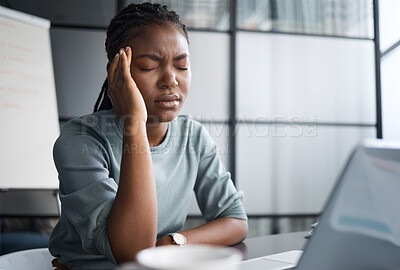 Buy stock photo Shot of a young businesswoman looking stressed out while working on a laptop in an office