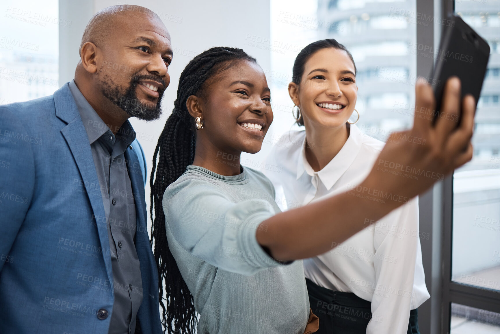 Buy stock photo Shot of a group of businesspeople taking selfies together in an office