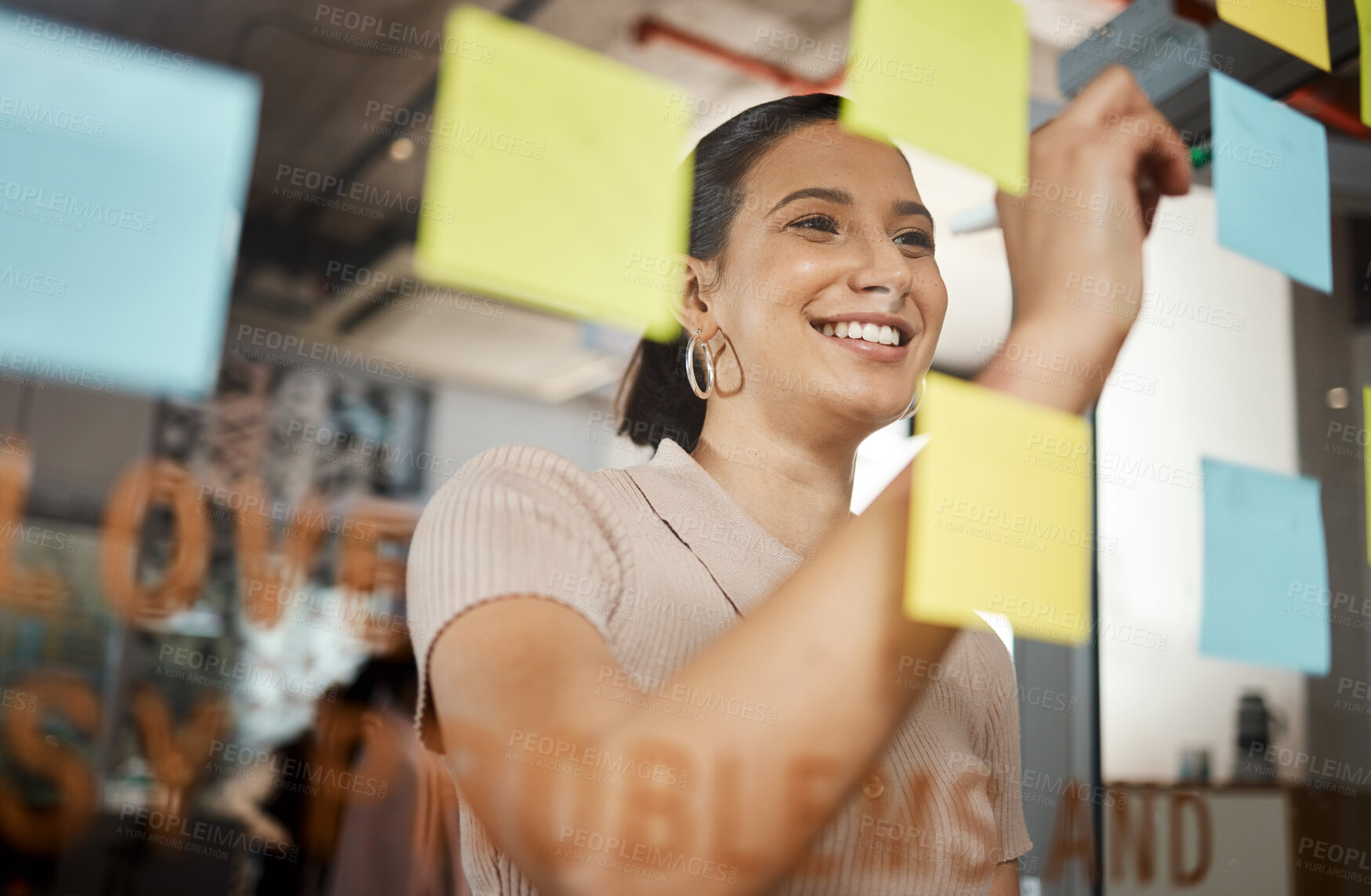 Buy stock photo Shot of a businesswoman brainstorming with sticky notes on a glass screen