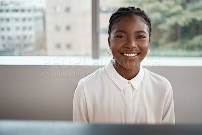 Buy stock photo Shot of a confident young businesswoman sitting at her desk