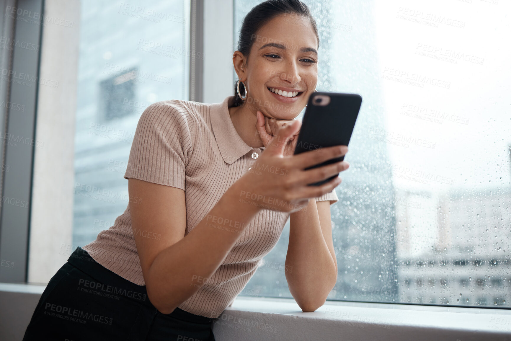 Buy stock photo Shot of a young businesswoman using her cellphone at the office