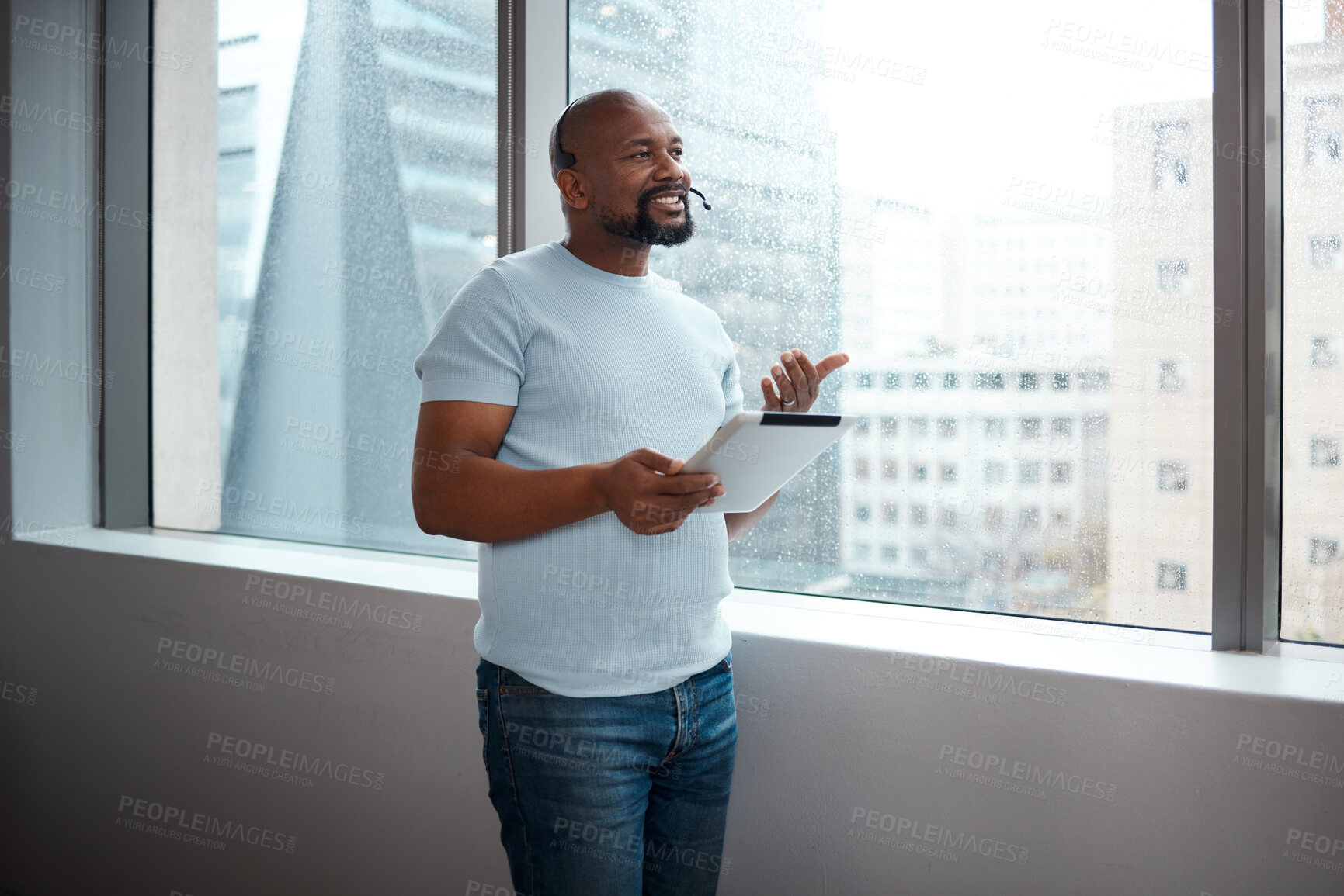 Buy stock photo Shot of a man using a digital tablet while working in a call center