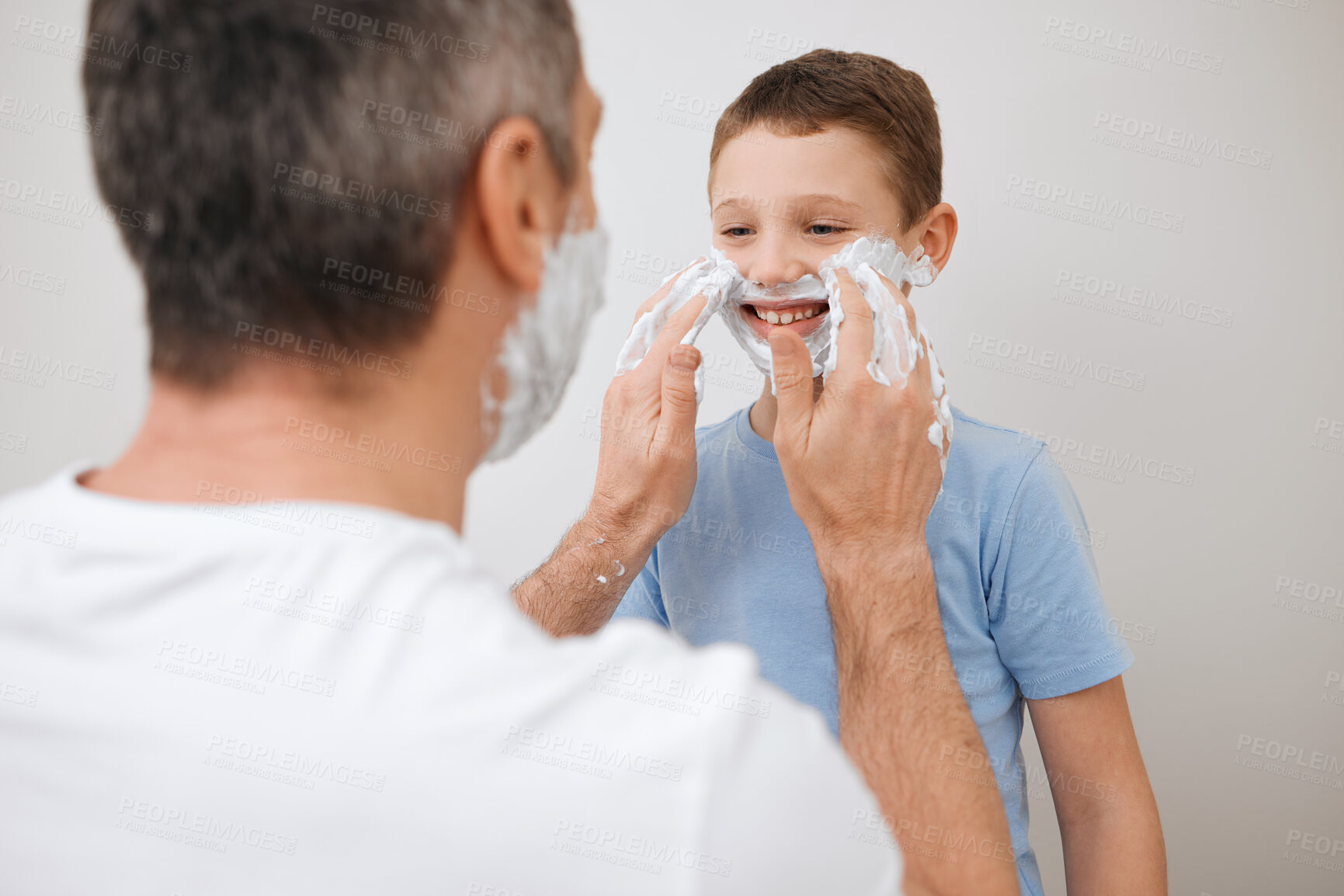 Buy stock photo Cropped shot of a handsome mature man teaching his young son how to shave in the bathroom at home