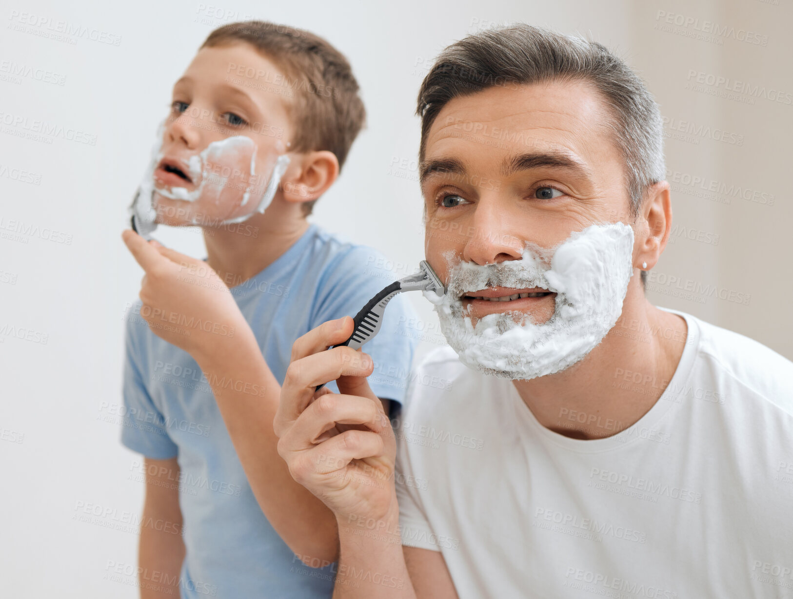 Buy stock photo Cropped shot of a handsome mature man teaching his young son how to shave in the bathroom at home