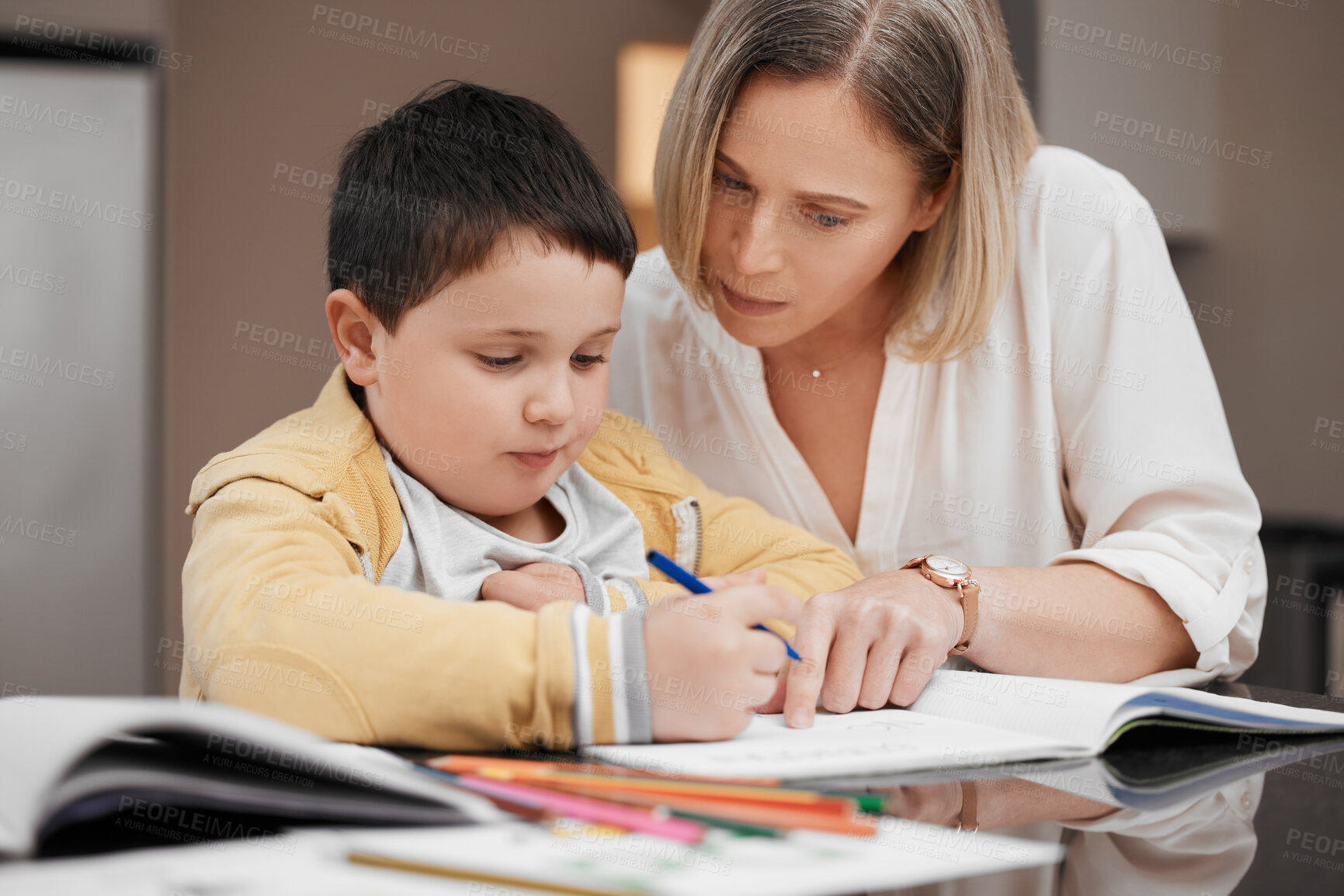 Buy stock photo Shot of a beautiful mother helping her son with his homework