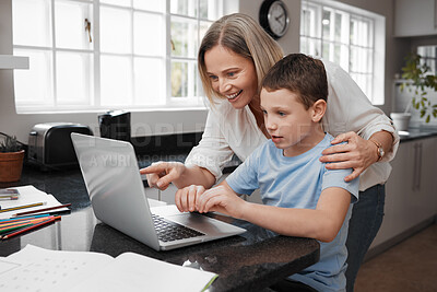 Buy stock photo Shot of a mother and son team using a laptop to complete home schooling work
