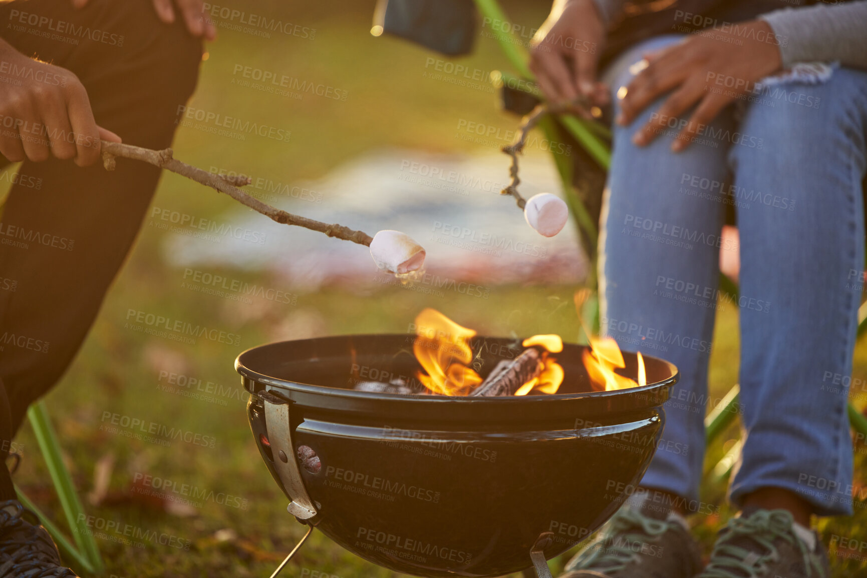 Buy stock photo Couple, toasting and marshmallow by fire on camping in forest with love, bonding and memories for adventure. People, sweets and food for dessert by flame in nature on vacation or holiday on picnic
