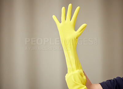Buy stock photo Shot of a young woman applying cleaning rubber gloves