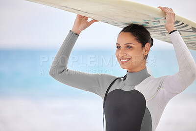 Buy stock photo Shot of a young woman holding a surfboard at the beach