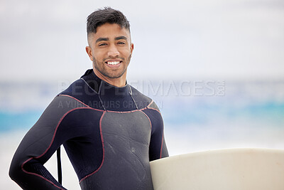 Buy stock photo Shot of a young man holding a surfboard at the beach