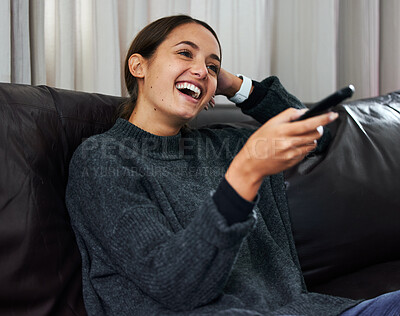 Buy stock photo Young woman, funny show and remote on sofa for happiness, relax and watching tv in apartment. Gen z, entertainment and laugh on couch for film, vacation and streaming in house for comedy or humour