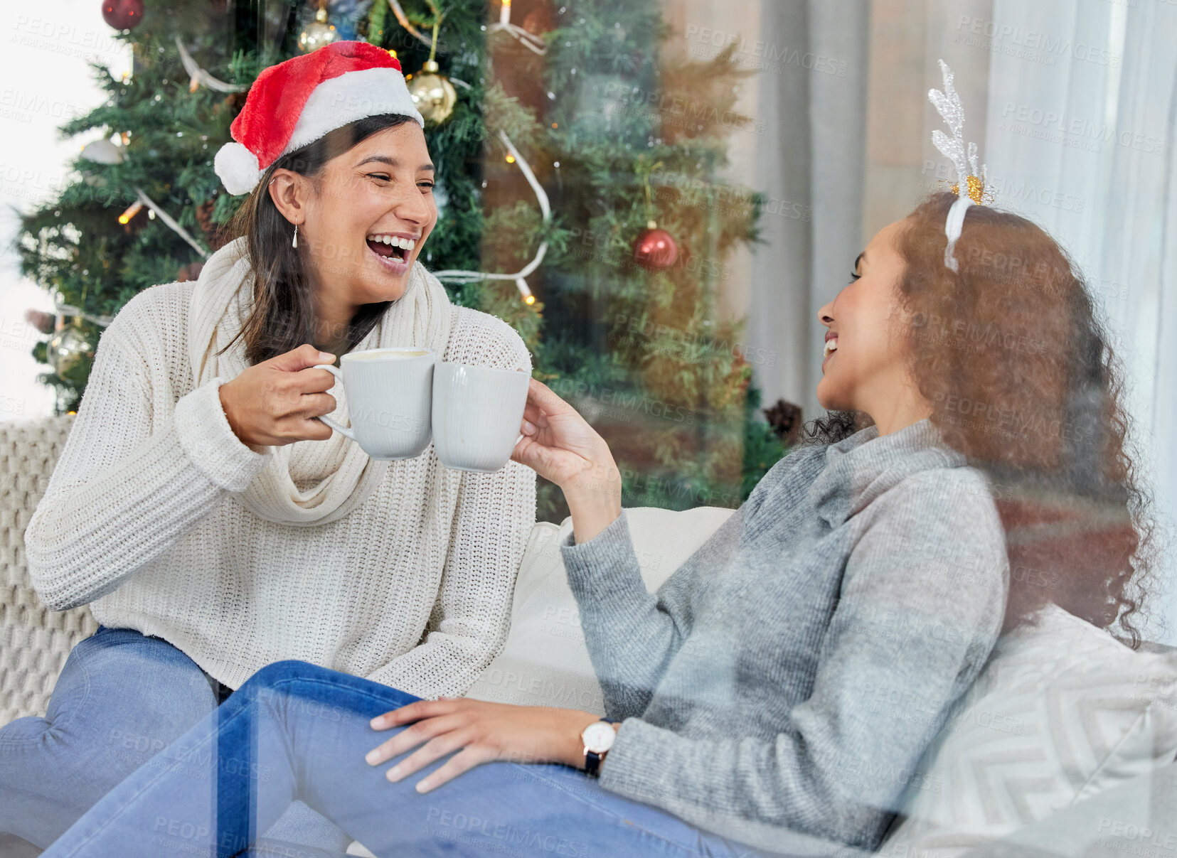 Buy stock photo Happy woman, friends and Christmas with coffee on sofa at home for celebration or festive season. Female person or people laughing with smile for conversation, funny joke or drink on December holiday