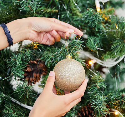 Buy stock photo Person, hands and bauble with Christmas tree for decoration, festive or holiday season at home. Closeup of ornament, lights and decor with glitter ball in December celebration or new year preparation