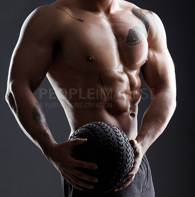 Buy stock photo Shot of an athletic young man using a slam ball during his workout