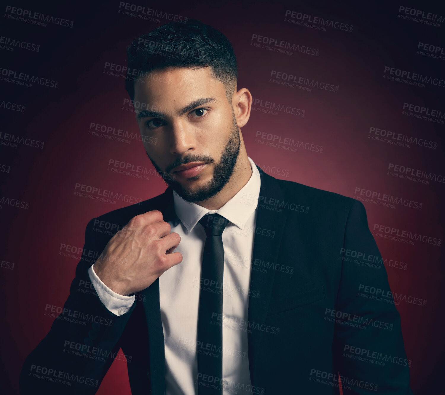 Buy stock photo Studio shot of a young man posing against a red background