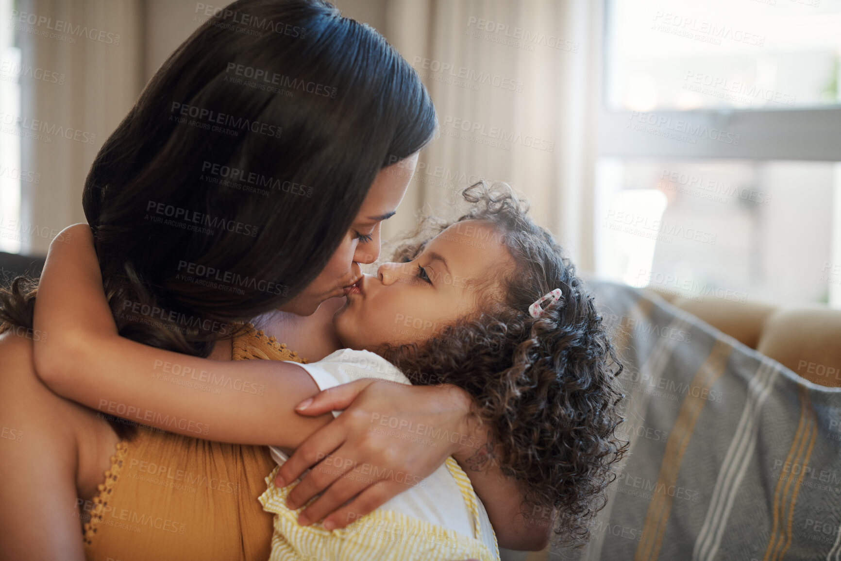 Buy stock photo Mom, girl and kiss with hug on sofa for bonding with love, affection and childhood security for support. Mother, child and relax with care in living room of home, together and nurture connection.