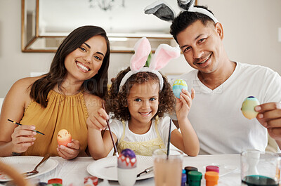 Buy stock photo Shot of a family painting Easter eggs together
