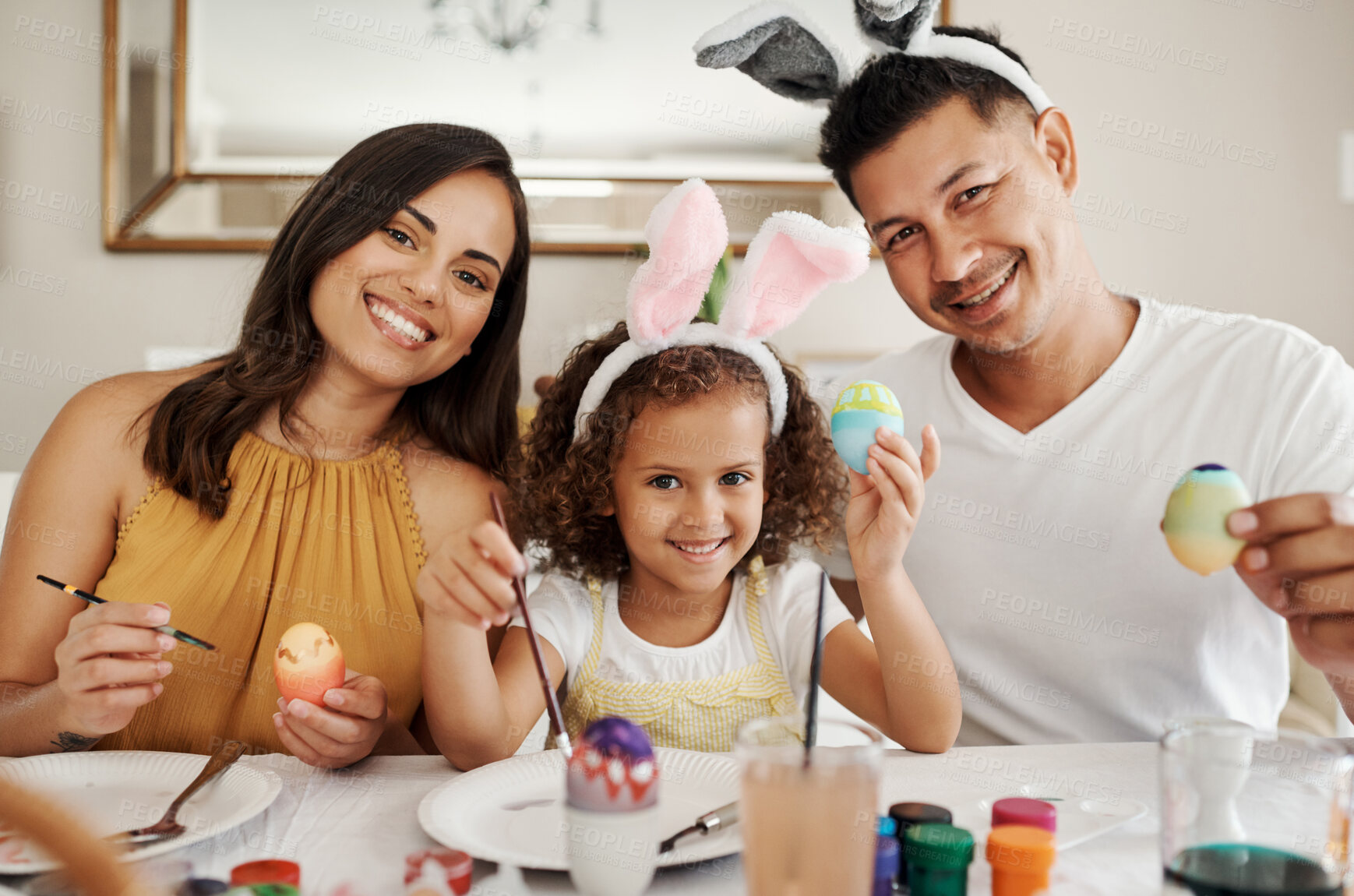 Buy stock photo Shot of a family painting Easter eggs together