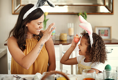 Buy stock photo Shot of a mother and daughter showing each other their painted easter eggs