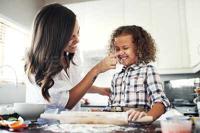 Buy stock photo Shot of an adorable little girl baking with her mom at home