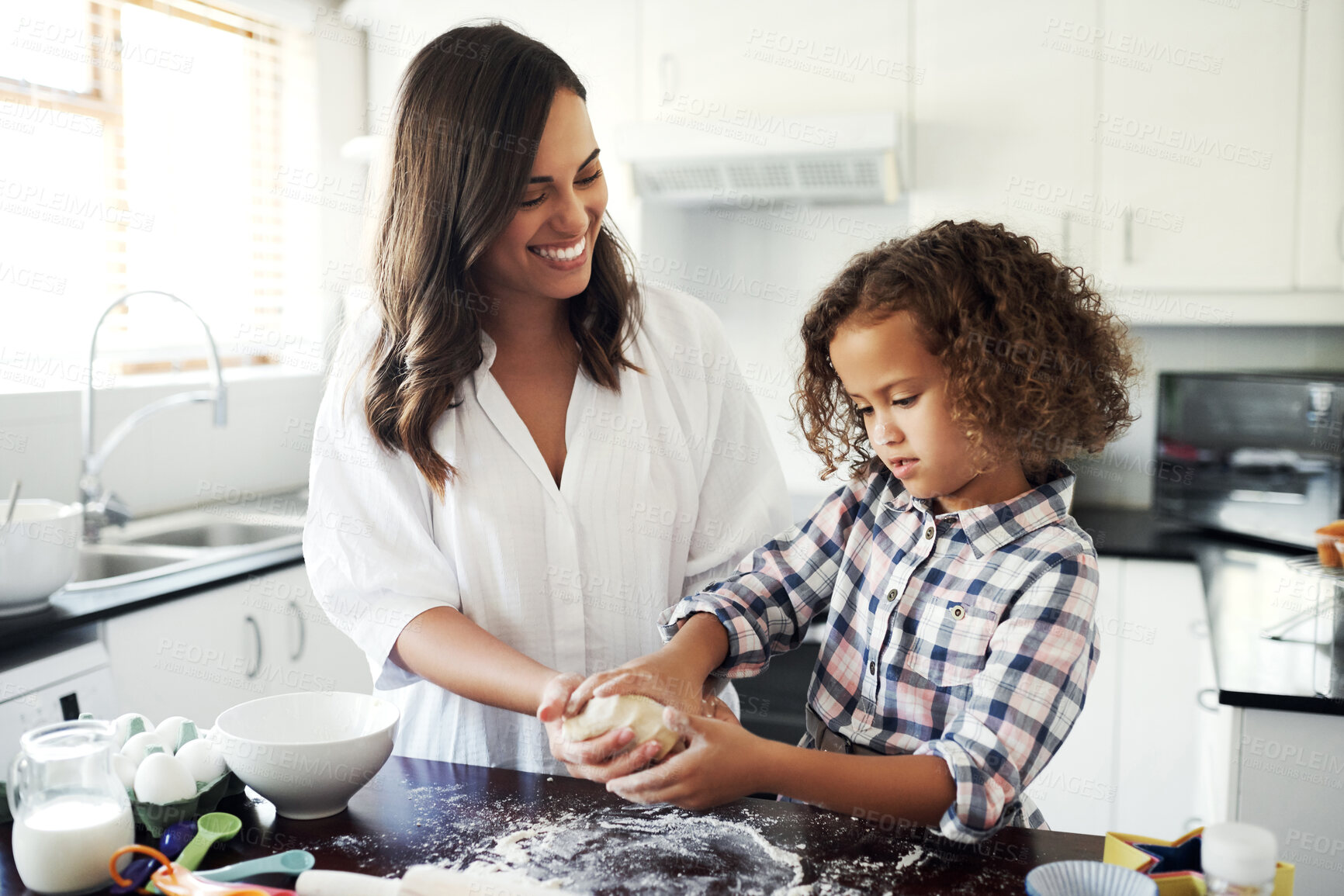 Buy stock photo Shot of an adorable little girl baking with her mom at home