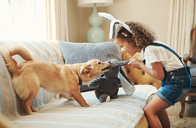 Buy stock photo Shot of an adorable young girl standing in the living room at home and playing with her dog