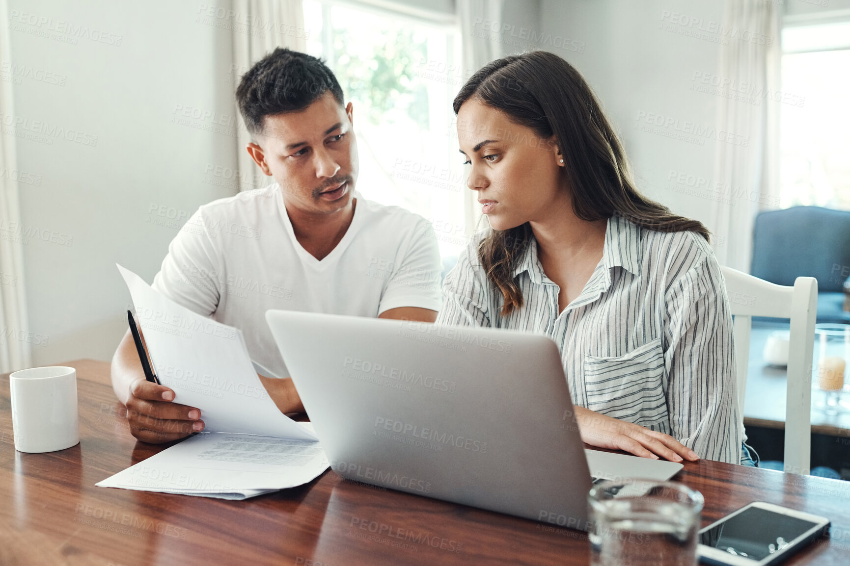 Buy stock photo Cropped shot of a young couple using a laptop to their household budget in the living room at home