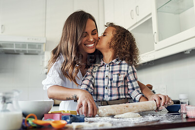 Buy stock photo Shot of an adorable little girl being affectionate while baking with her mom at home