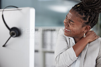 Buy stock photo Shot of a young female call center agent suffering from back pain in an office at work