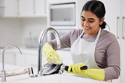 Buy stock photo Shot of a young woman doing the dishes at home