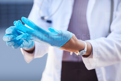 Buy stock photo Shot of an unrecognizable doctor putting on surgical gloves outside