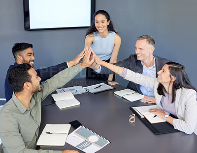 Buy stock photo Shot of a group of businesspeople giving each other a high five during a meeting in an office