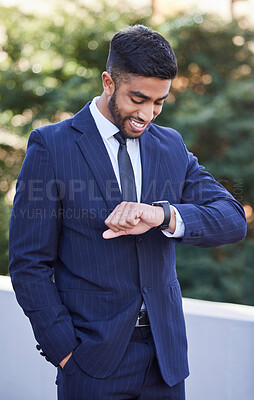 Buy stock photo Shot of a young businessman checking the time in the city