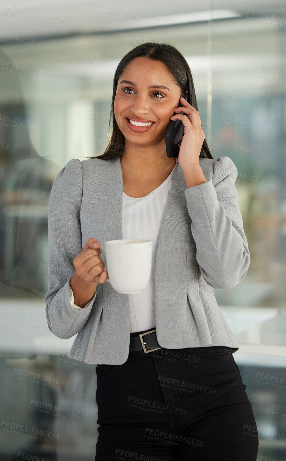 Buy stock photo Shot of a young businesswoman using a smartphone and having coffee in a modern office