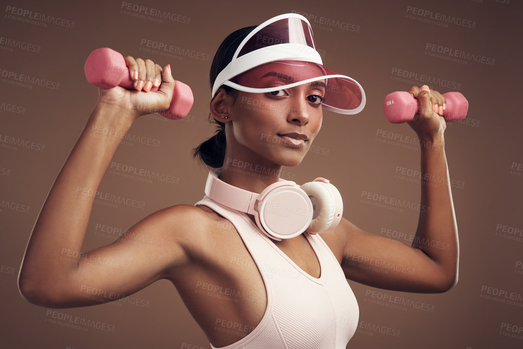 Buy stock photo Woman, fitness and smile with dumbbells in studio for portrait, visor or fashion on brown background. Girl, training and equipment for workout, exercise or weightlifting for healthy body in Sri Lanka