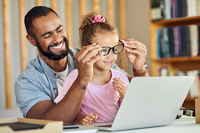 Buy stock photo Shot of a young father showing his daughter his work while playing around with his glasses